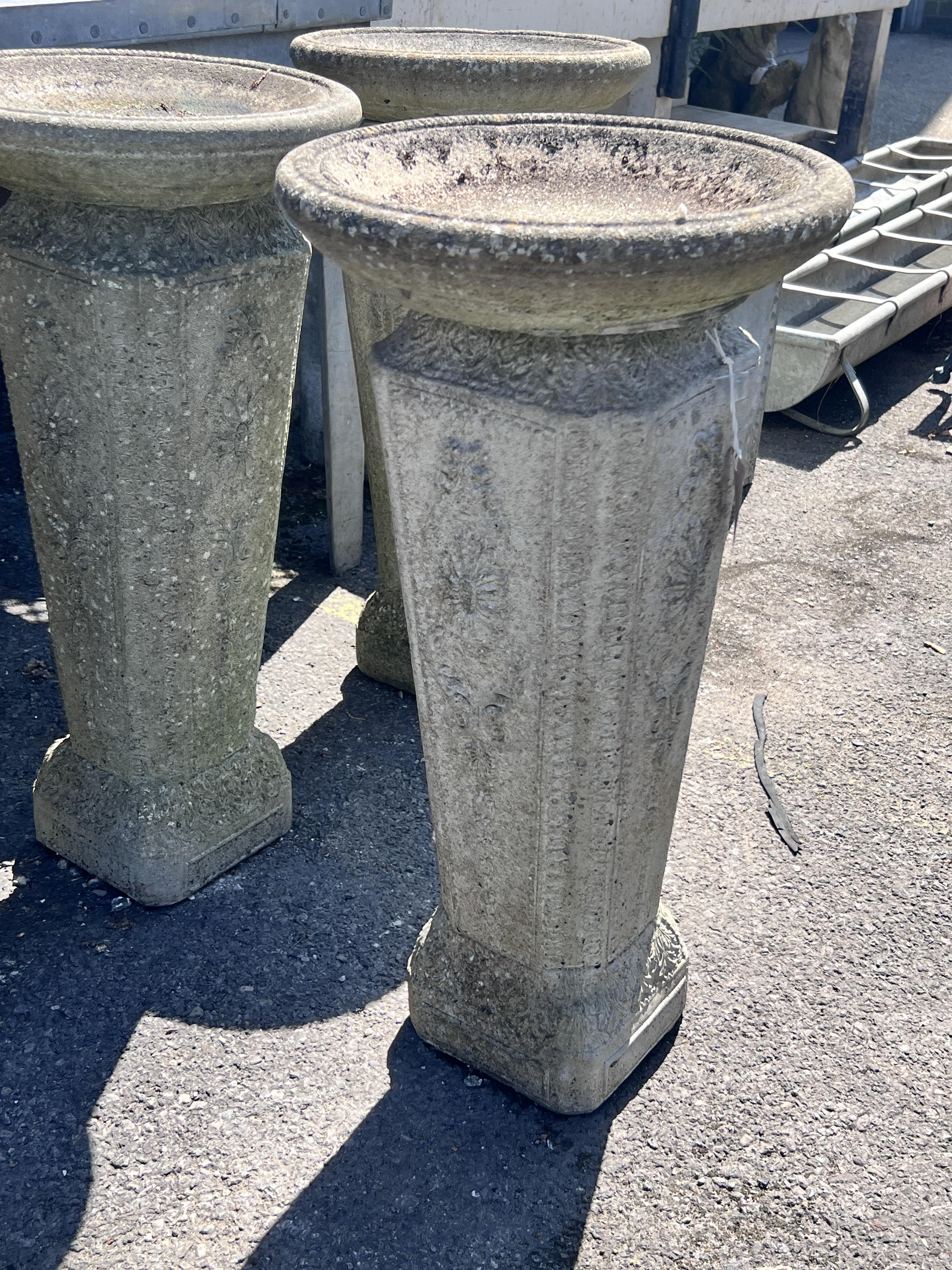 A set of four reconstituted stone circular bird baths, height 74cm